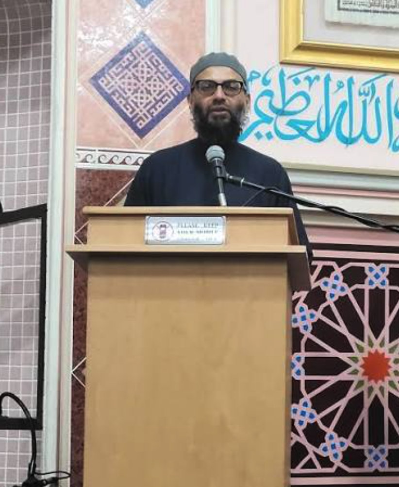 Shaykh Hamza Karamali speaking from the lectern